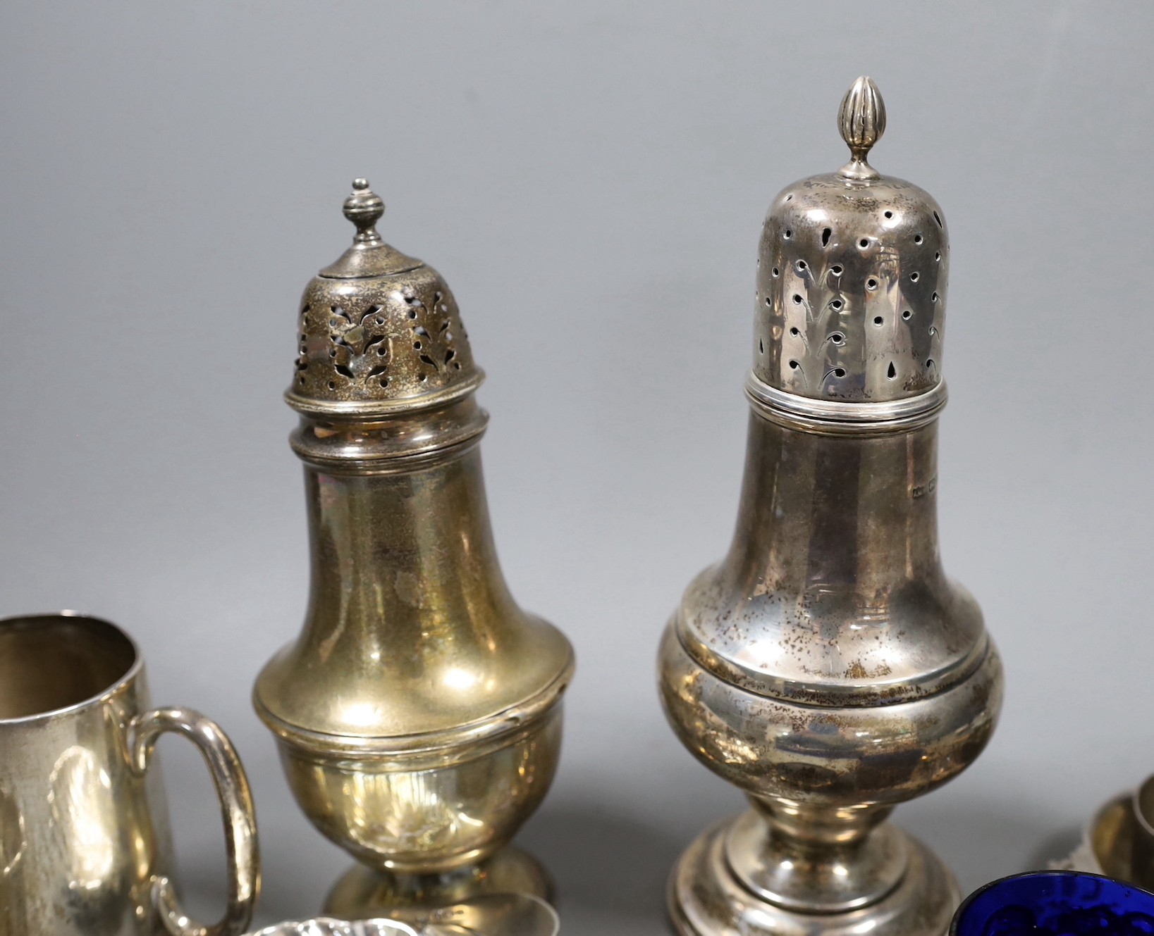 Sundry small silver including two sugar casters, tallest Chester, 1922, 21cm, two mugs, match sleeve, quaich, wine label and three napkin rings